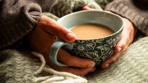 A person holds a patterned mug